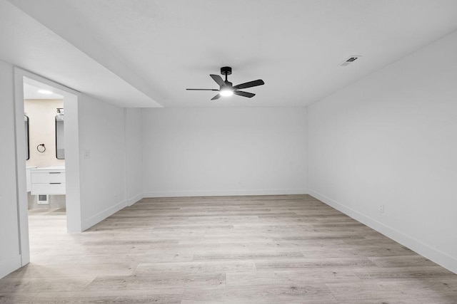 empty room with light wood-style floors, visible vents, baseboards, and a ceiling fan