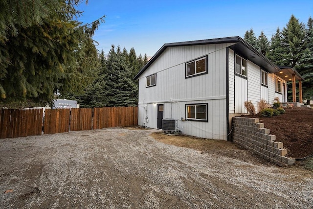 view of front of property with central AC unit and fence