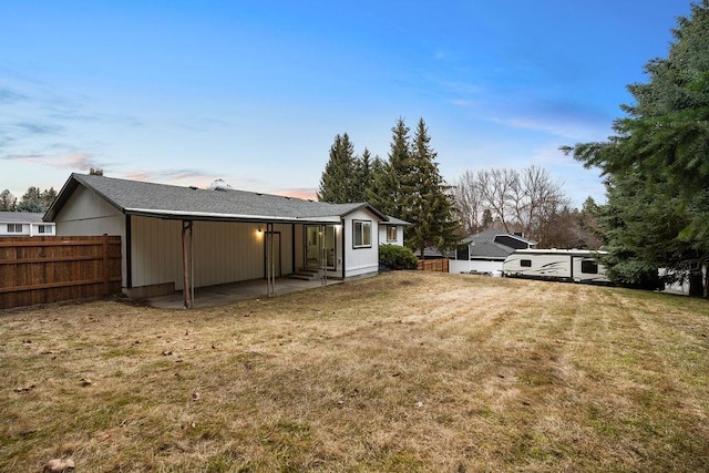 back of house featuring entry steps, a patio, a lawn, and fence