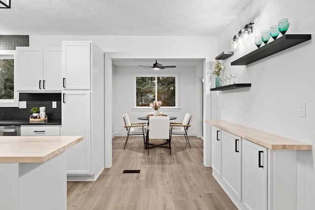 kitchen featuring butcher block counters, white cabinetry, light wood-style flooring, and open shelves