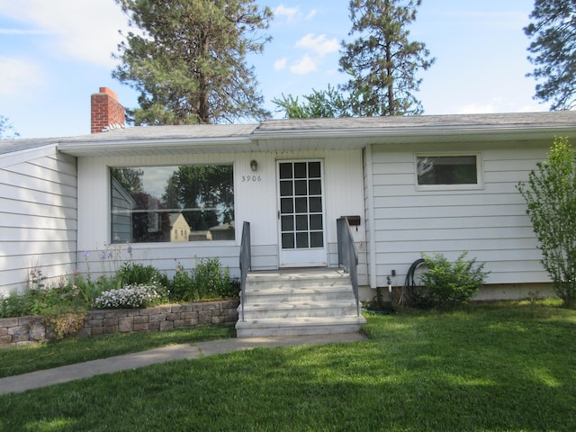 view of front facade featuring a chimney and a front lawn