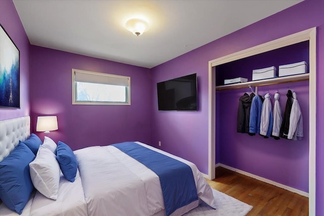 bedroom featuring a closet, baseboards, and wood finished floors