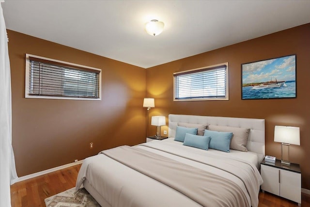 bedroom with baseboards and wood finished floors