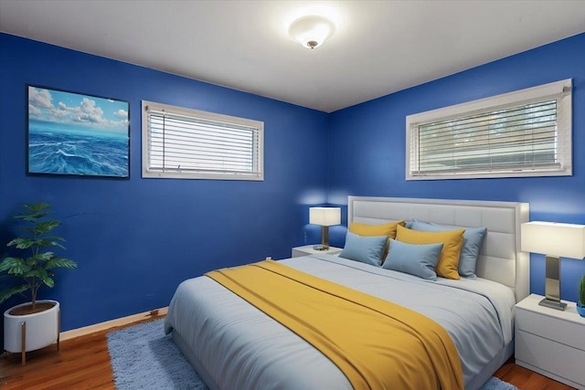 bedroom with baseboards and wood finished floors