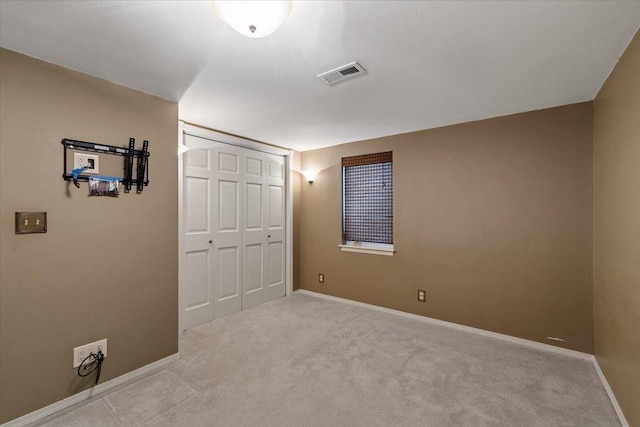 unfurnished bedroom with carpet, a closet, visible vents, and baseboards