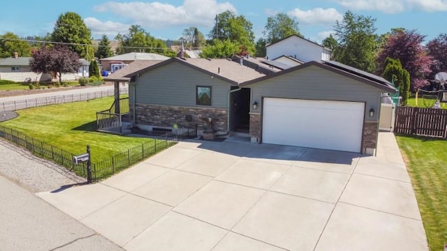 ranch-style home featuring solar panels, concrete driveway, an attached garage, a front yard, and fence