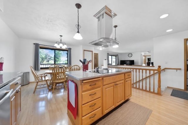 kitchen featuring pendant lighting, light wood finished floors, black electric stovetop, a kitchen island, and dishwasher