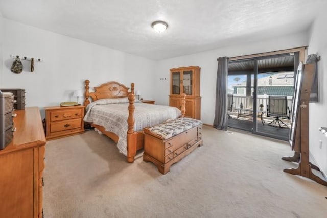 bedroom with access to outside and light colored carpet