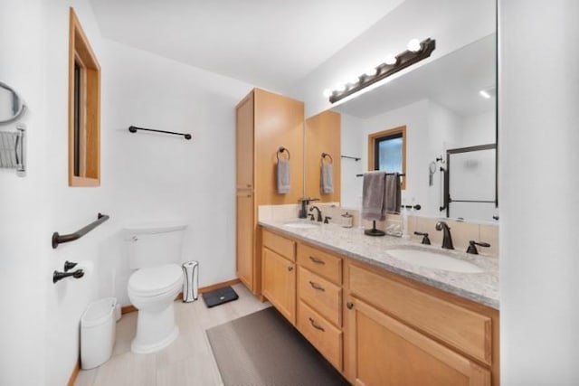 full bathroom featuring double vanity, a shower, a sink, and toilet