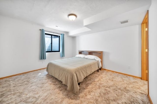 bedroom with baseboards, visible vents, and light colored carpet