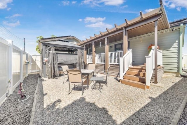 view of patio / terrace with outdoor dining area, a fenced backyard, and a gazebo