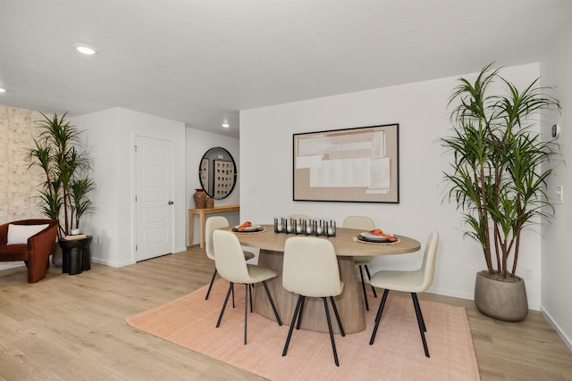 dining room with recessed lighting, baseboards, and light wood finished floors