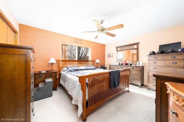 bedroom with a ceiling fan and light colored carpet