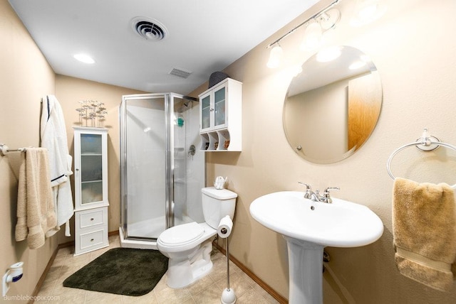 bathroom featuring visible vents, toilet, a stall shower, tile patterned flooring, and baseboards