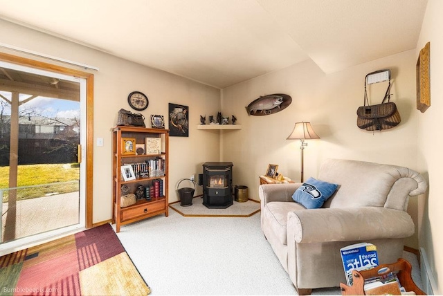 carpeted living room with a wood stove and baseboards