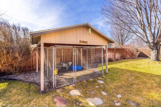 view of outbuilding featuring a carport, an outbuilding, an exterior structure, and a fenced backyard