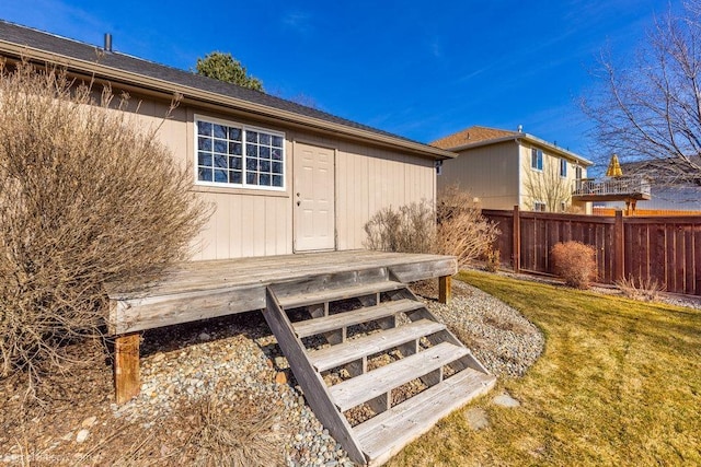 exterior space featuring a wooden deck, fence, and a yard