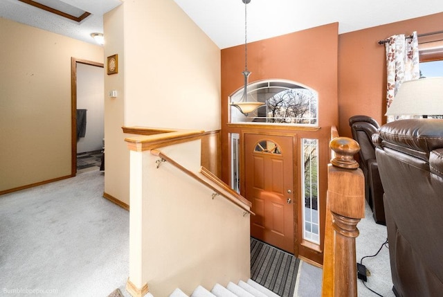 carpeted foyer entrance with high vaulted ceiling and baseboards