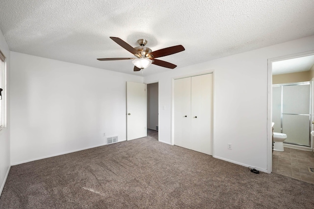 unfurnished bedroom with a textured ceiling, connected bathroom, visible vents, a closet, and carpet