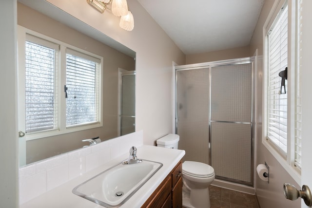 bathroom featuring a stall shower, plenty of natural light, vanity, and toilet