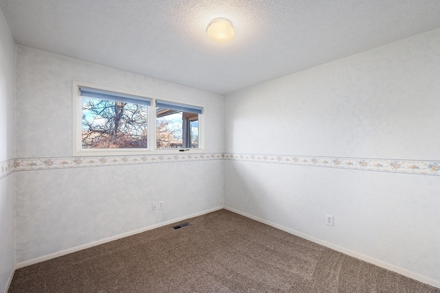 carpeted empty room featuring visible vents, a textured ceiling, and baseboards