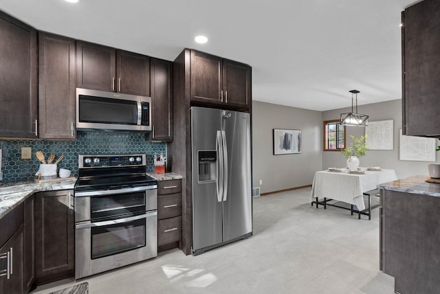 kitchen featuring dark brown cabinetry, baseboards, appliances with stainless steel finishes, light stone countertops, and tasteful backsplash