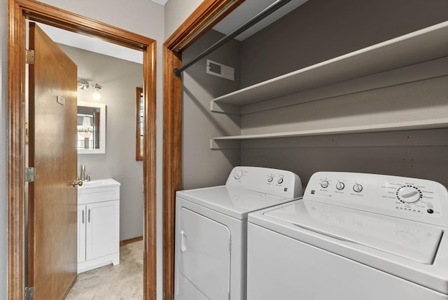 laundry room featuring visible vents, washer and clothes dryer, and a sink