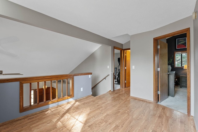 unfurnished room featuring a ceiling fan, lofted ceiling, and wood finished floors