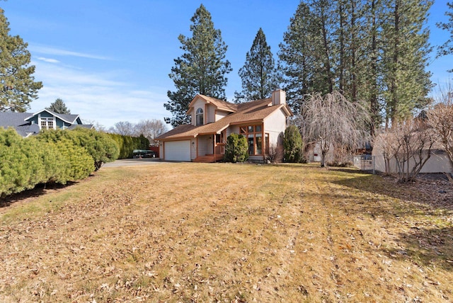 view of side of home featuring a garage, a yard, a chimney, and fence