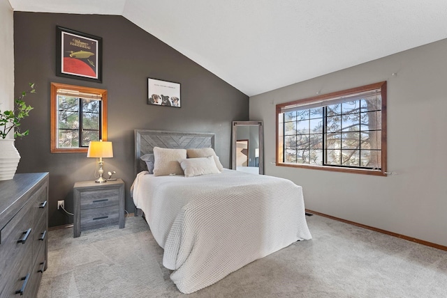 bedroom with light carpet, multiple windows, and vaulted ceiling