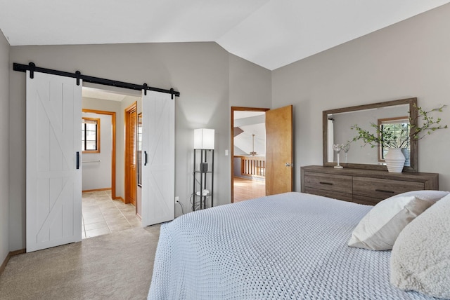 bedroom featuring lofted ceiling, a barn door, baseboards, and light colored carpet