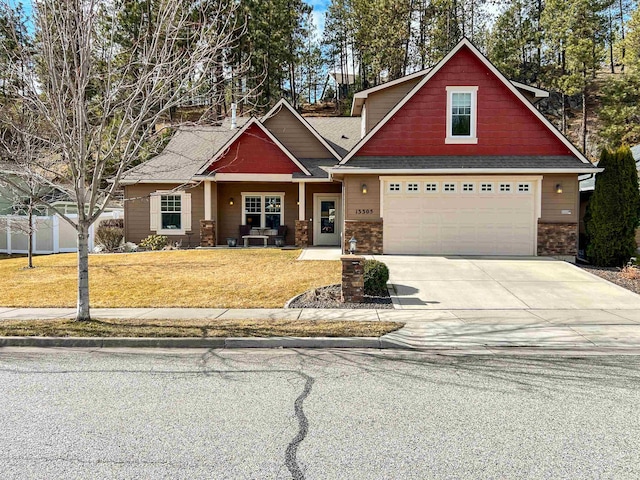 craftsman-style home featuring a front yard, concrete driveway, roof with shingles, and fence