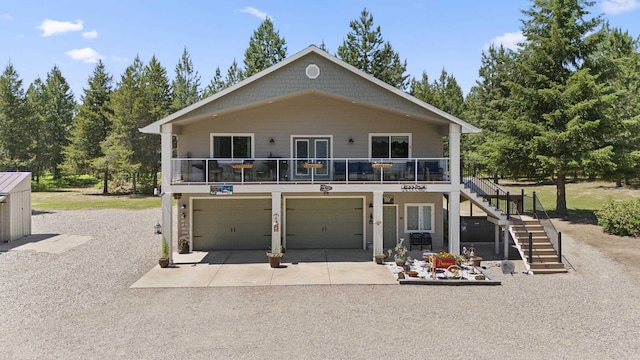 view of front of home with stairs, concrete driveway, and an attached garage