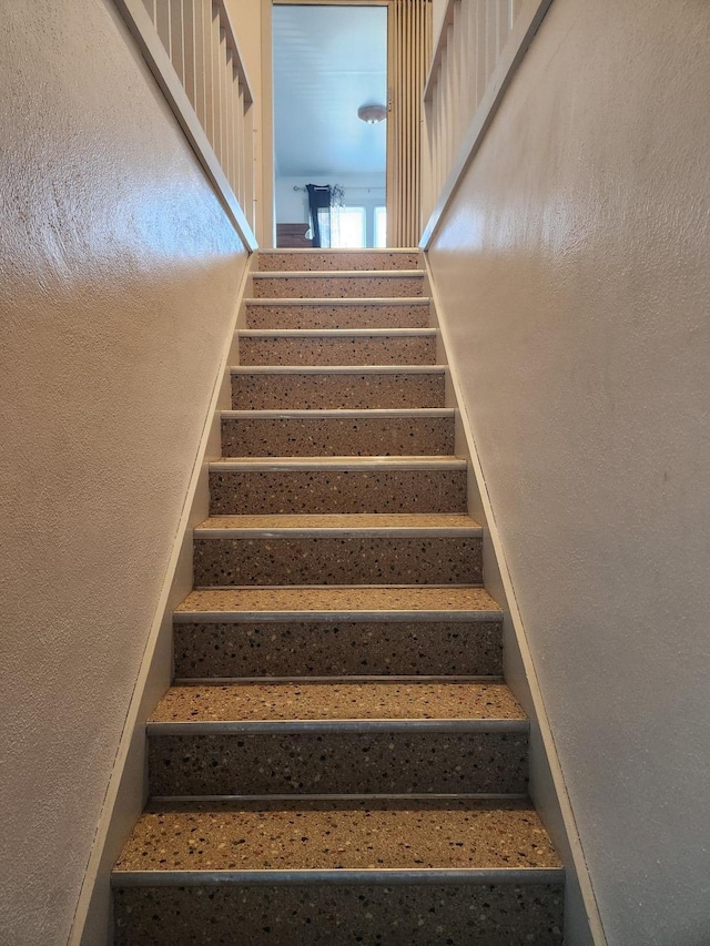 staircase with a textured wall