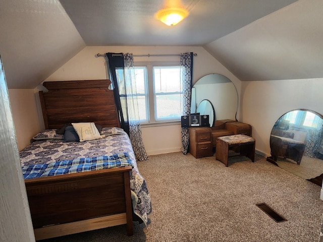 bedroom featuring vaulted ceiling, carpet flooring, visible vents, and baseboards