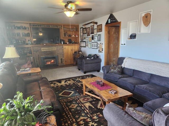 living room featuring ceiling fan, carpet floors, and a fireplace