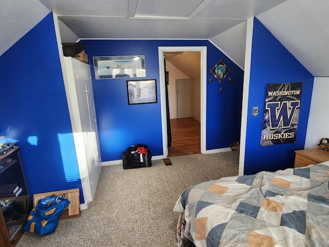 bedroom with vaulted ceiling, carpet flooring, and baseboards