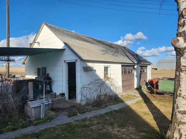 view of side of home with roof with shingles