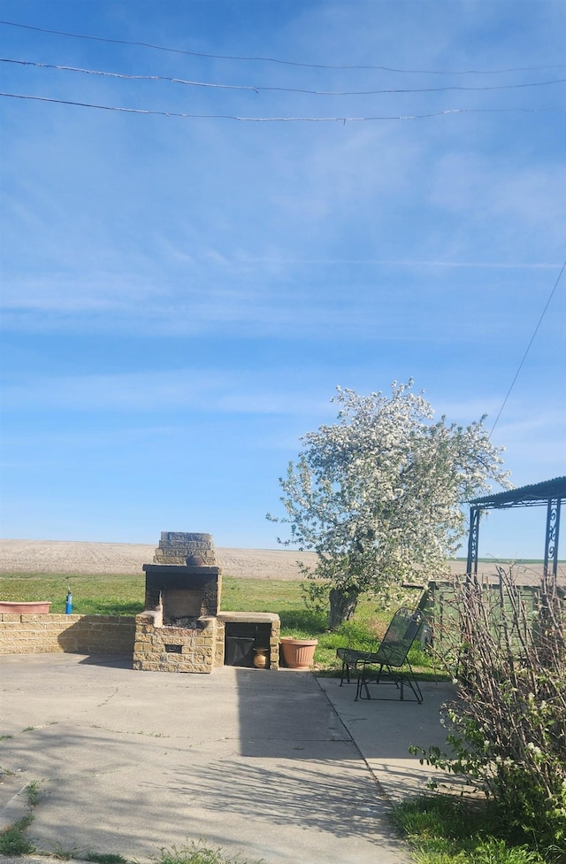 15650 Huddle Corner Rd, Harrington, WA 99134 - view of patio / terrace featuring a rural view and an outdoor stone fireplace
