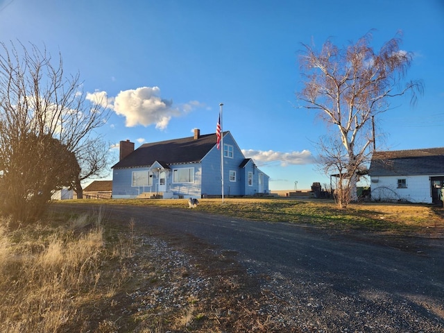 view of side of property featuring driveway and a chimney