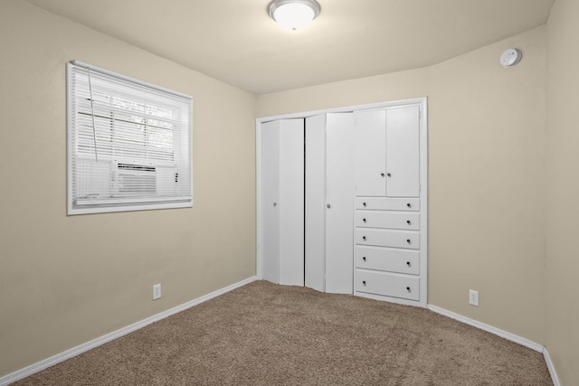 unfurnished bedroom with cooling unit, carpet, baseboards, and a closet