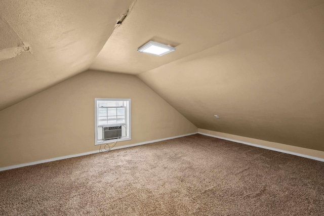 additional living space with carpet floors, lofted ceiling, a textured ceiling, cooling unit, and baseboards