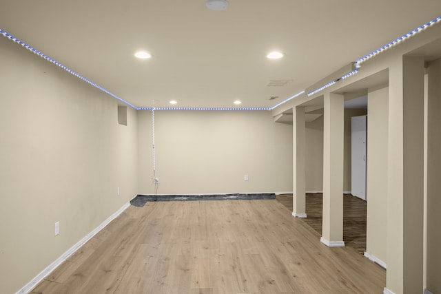 finished basement featuring light wood-style floors, recessed lighting, and baseboards