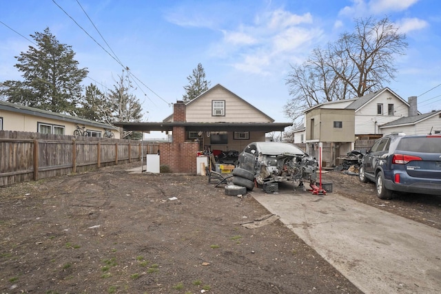 back of property with a chimney and fence