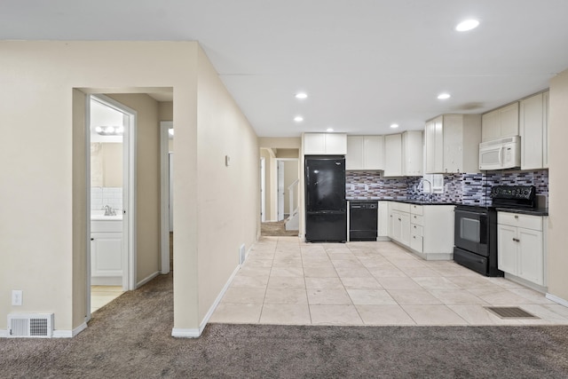 kitchen with black appliances, dark countertops, backsplash, and visible vents