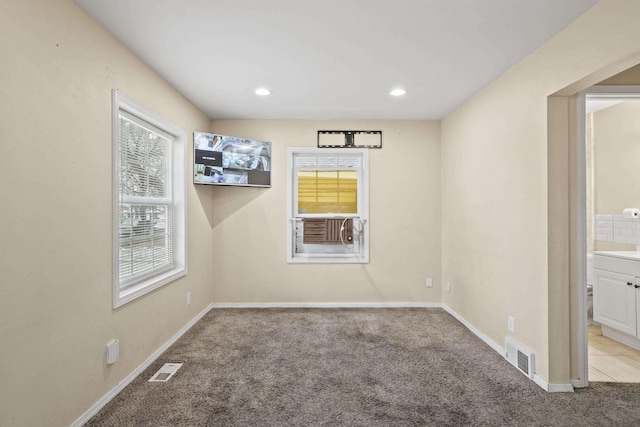 carpeted empty room featuring recessed lighting, visible vents, and baseboards