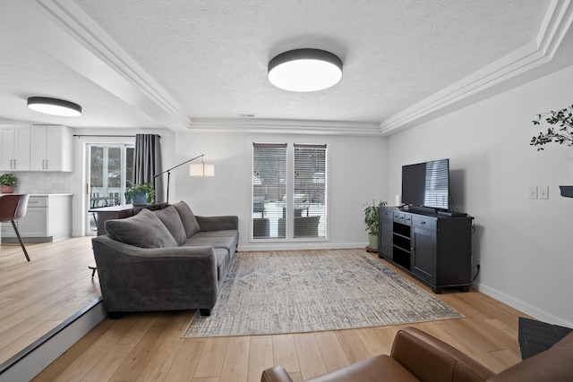 living room featuring a textured ceiling, light wood-type flooring, and baseboards