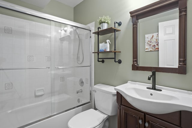 bathroom with combined bath / shower with glass door, vanity, and toilet