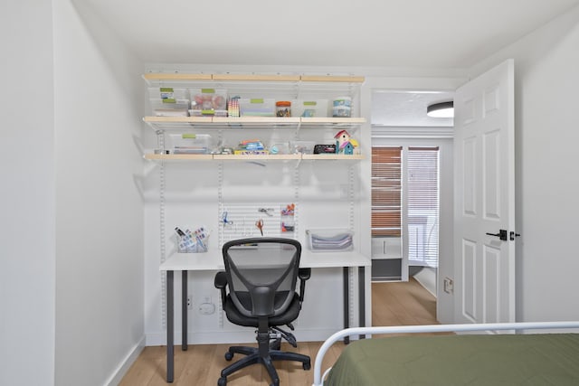 office area featuring baseboards and light wood finished floors