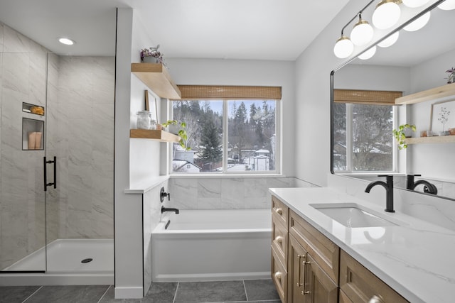 full bathroom featuring a stall shower, a garden tub, and vanity